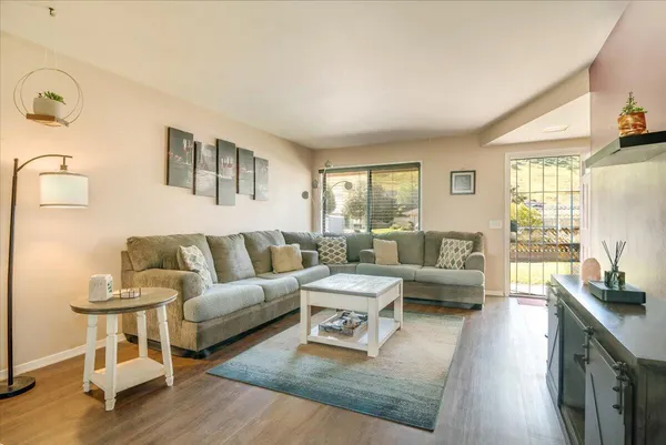 a living room with furniture and a wooden floor