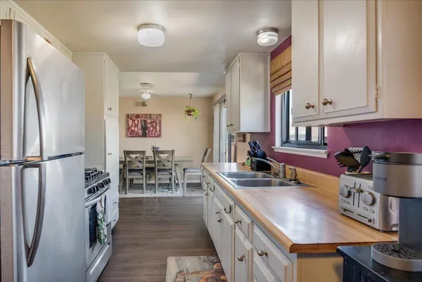 a kitchen with sink refrigerator and cabinets
