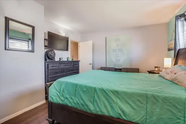 a bedroom with a bed window and a flat screen tv