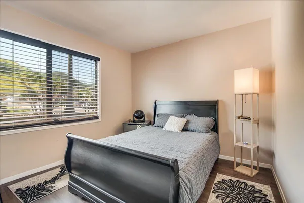 a bedroom with a bed and a lamp next to a window