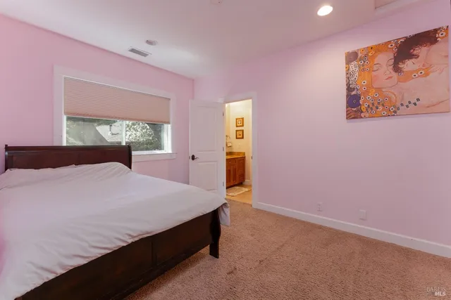 a bedroom with a bed and a painting on the wall