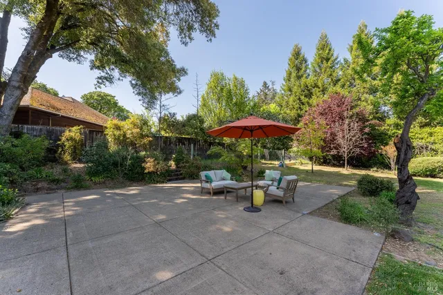 a view of backyard with outdoor seating and trees