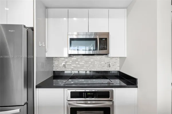 a kitchen with granite countertop a stove and a microwave
