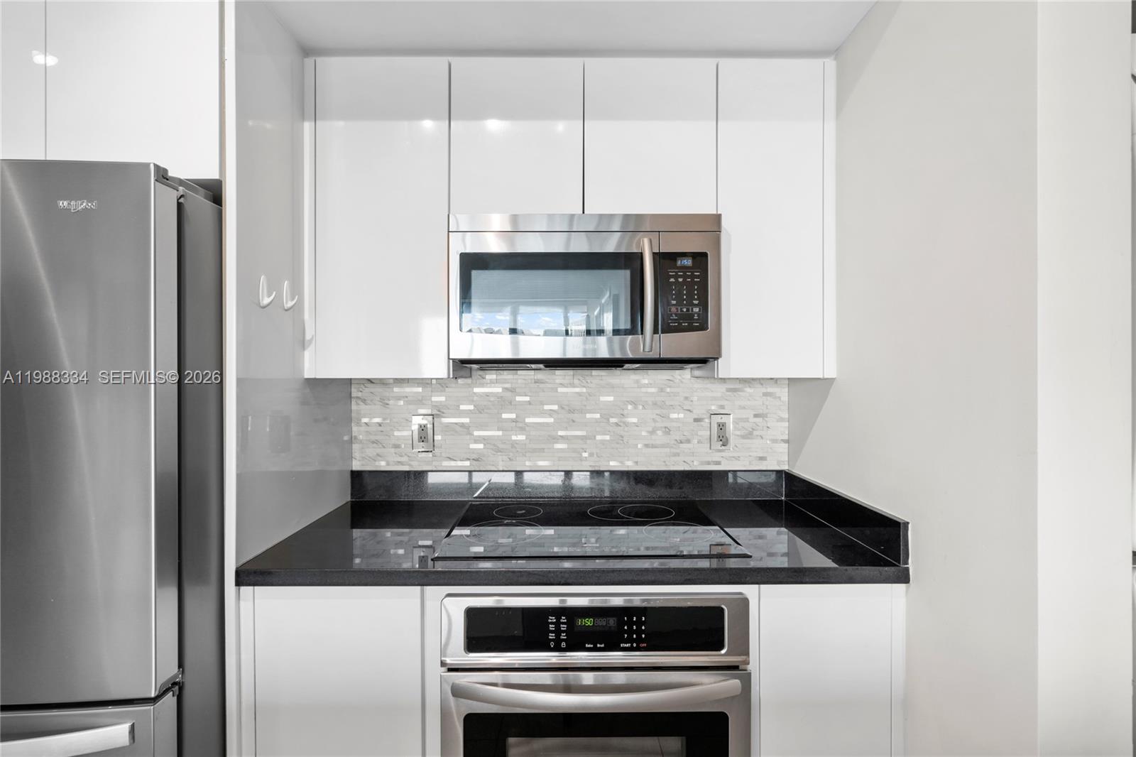 92 Southwest 3rd Street, Unit 4702 Miami, FL 33130 - Photo 15 of 47 a kitchen with granite countertop a stove and a microwave
