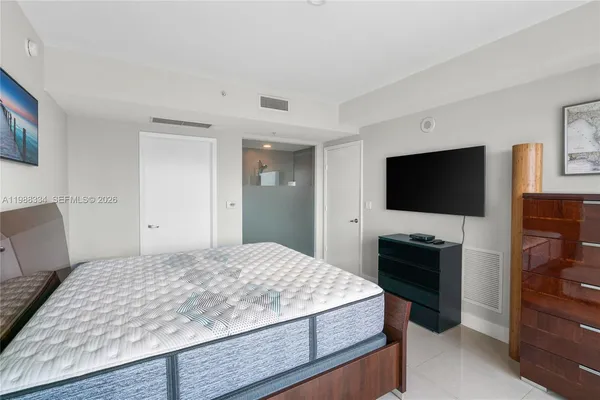 a bedroom with a bed and a flat screen tv