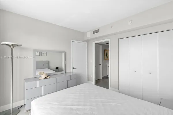 a large white room with a double vanity sink and mirror