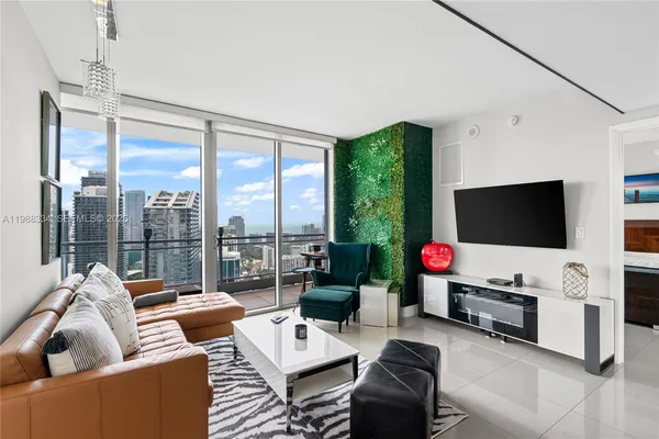 a living room with furniture a flat screen tv and a floor to ceiling window