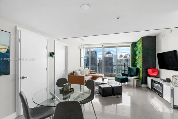 a living room with furniture flat screen tv and a large window