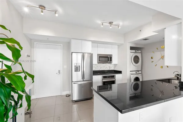 a kitchen with stainless steel appliances granite countertop a sink a stove and a refrigerator