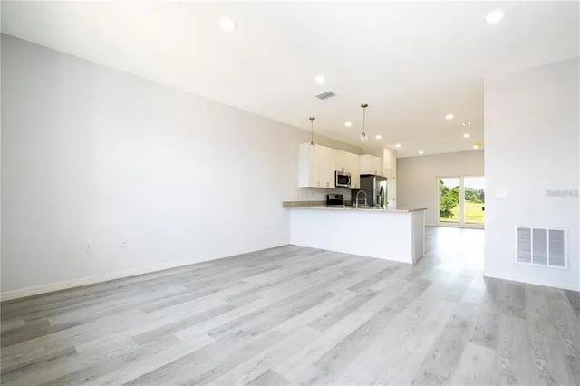 a view of kitchen with kitchen island and stainless steel appliances