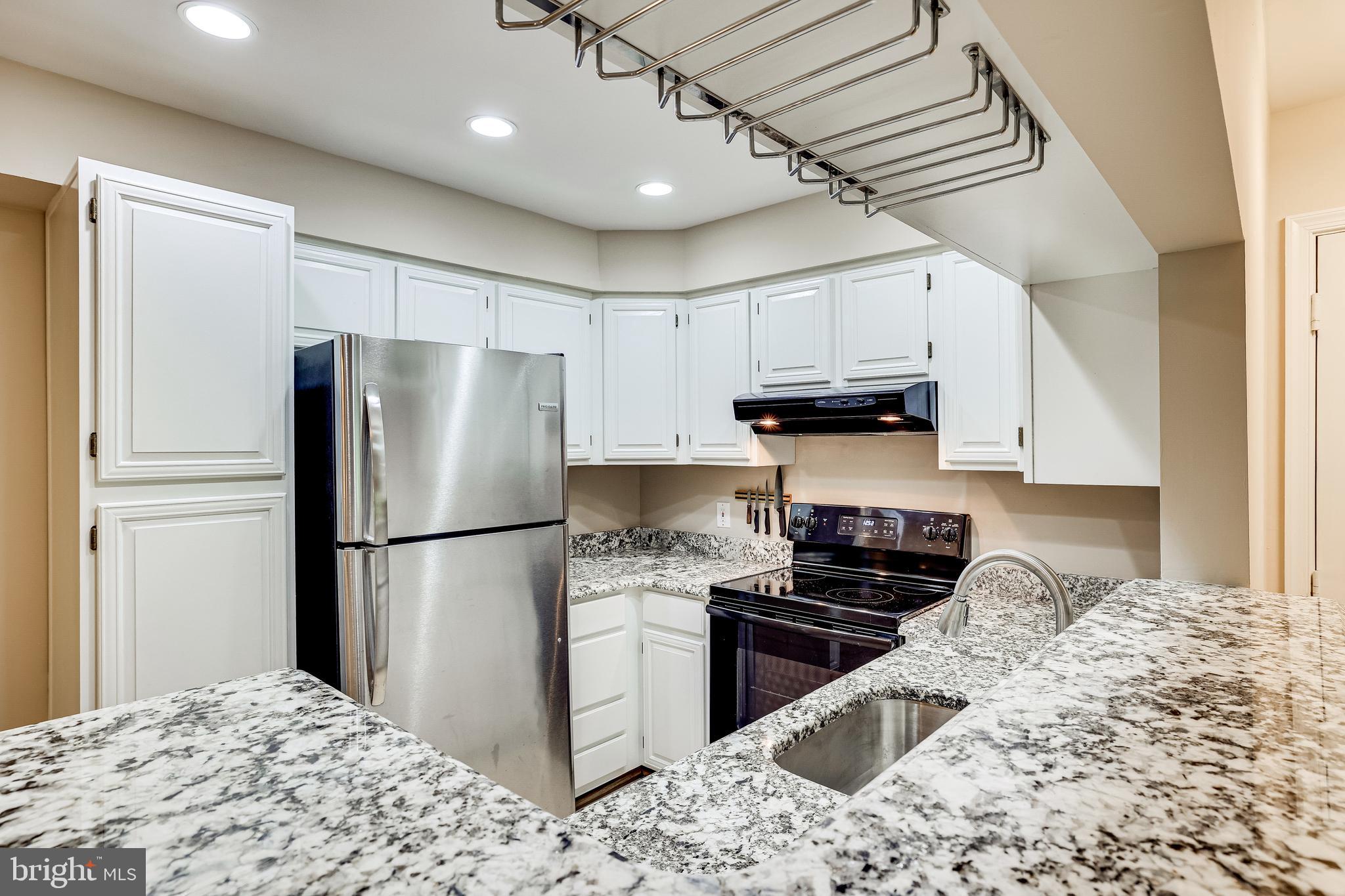 2229 Lovedale Lane, Unit G Reston, VA 20191 - Photo 14 of 38 a kitchen with kitchen island granite countertop a refrigerator stove top oven and sink