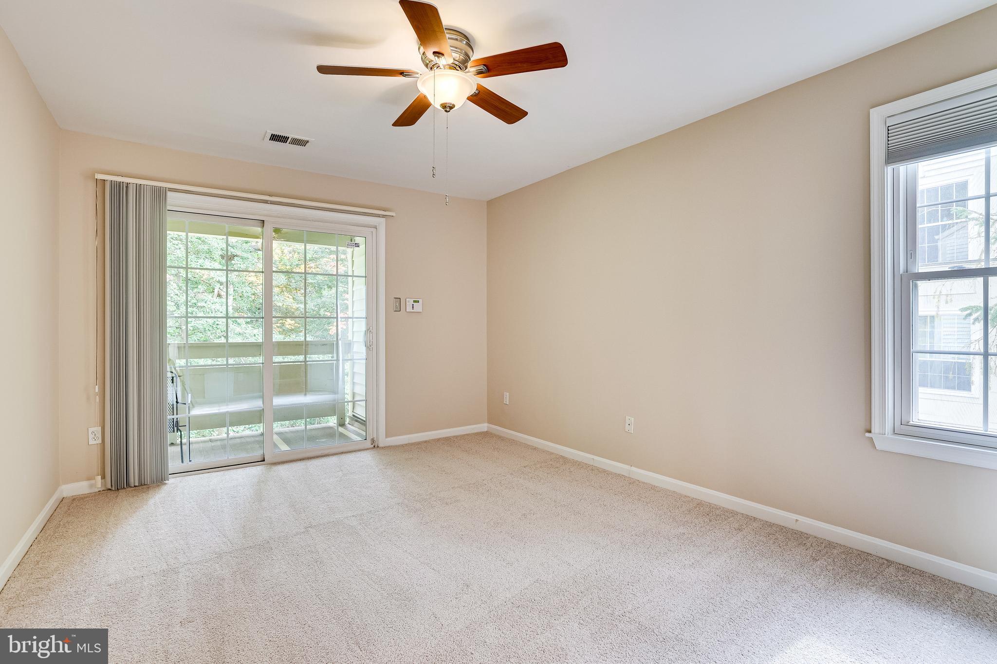 2229 Lovedale Lane, Unit G Reston, VA 20191 - Photo 17 of 38 an empty room with chandelier fan and windows