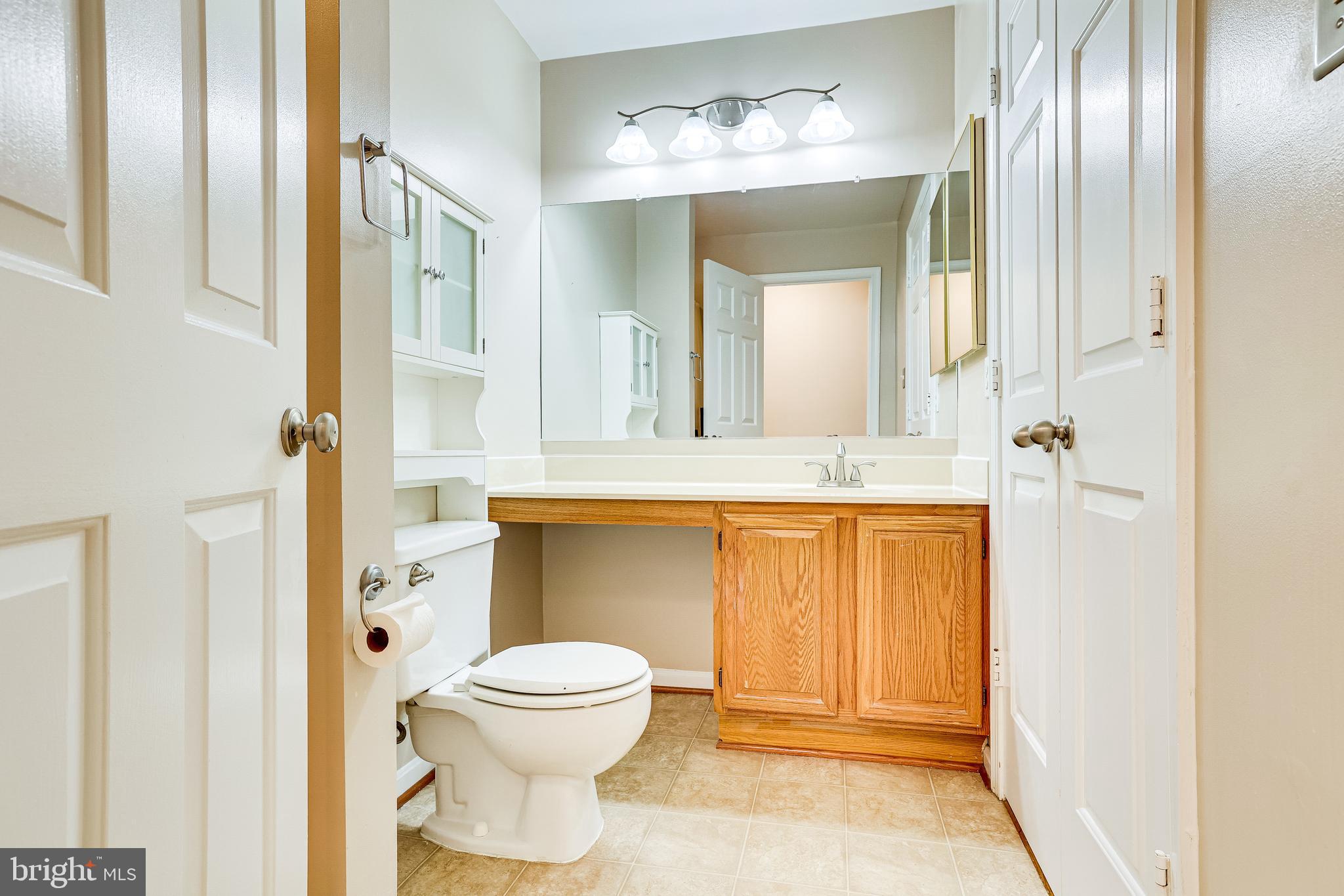 2229 Lovedale Lane, Unit G Reston, VA 20191 - Photo 24 of 38 a bathroom with a toilet a sink and mirror