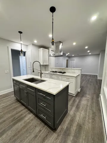 a kitchen with stainless steel appliances granite countertop a sink counter space and wooden floor