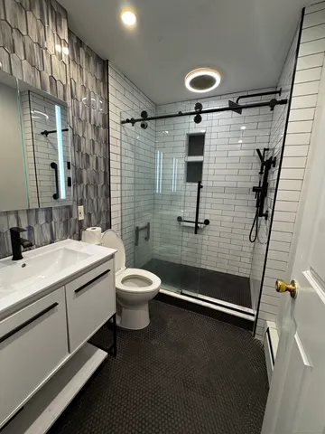a bathroom with a sink a toilet and shower