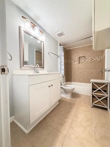a spacious bathroom with a double vanity sink toilet and mirror