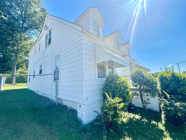 a view of backyard with potted plants and large tree