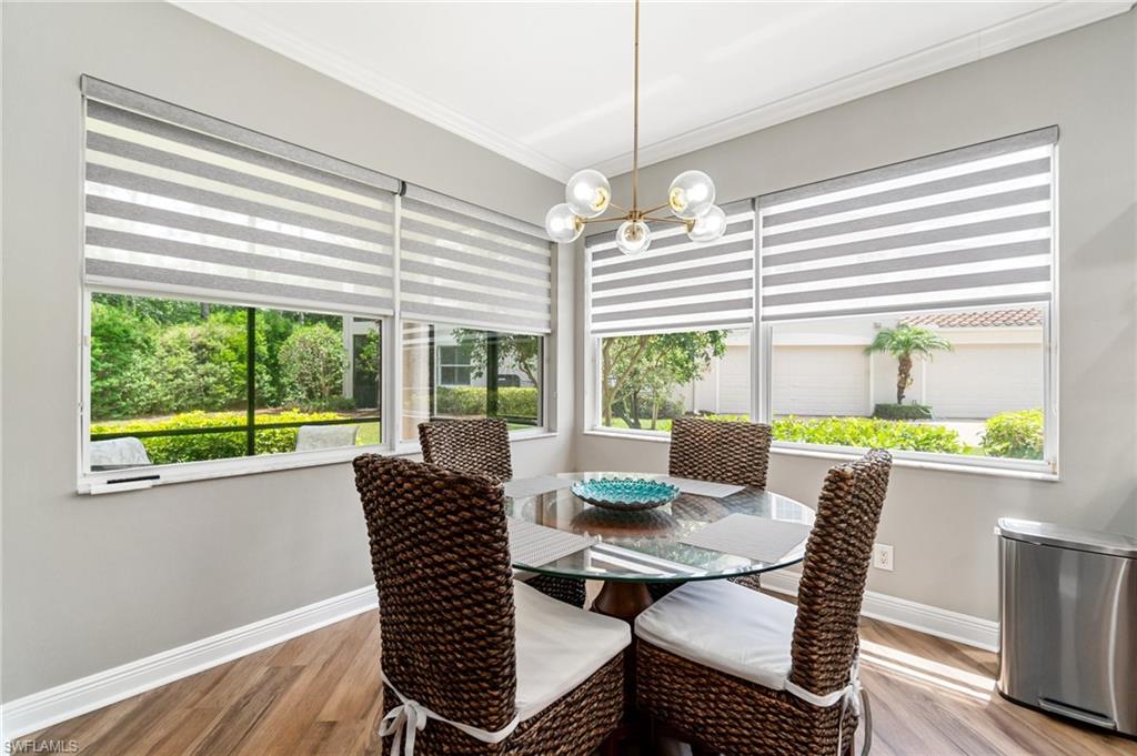 11000 Carrara Court, Unit 102 Bonita Springs, FL 34135 - Photo 11 of 31 a view of a dining room with furniture a chandelier and wooden floor