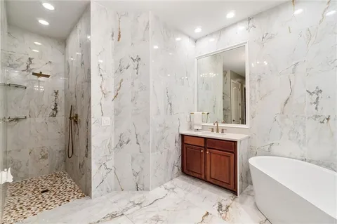 a bathroom with a bathtub sink and mirror