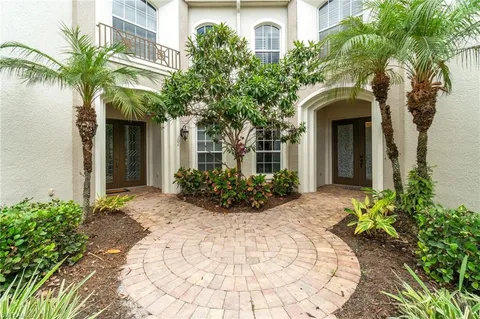 a view of a house with potted plants and large trees