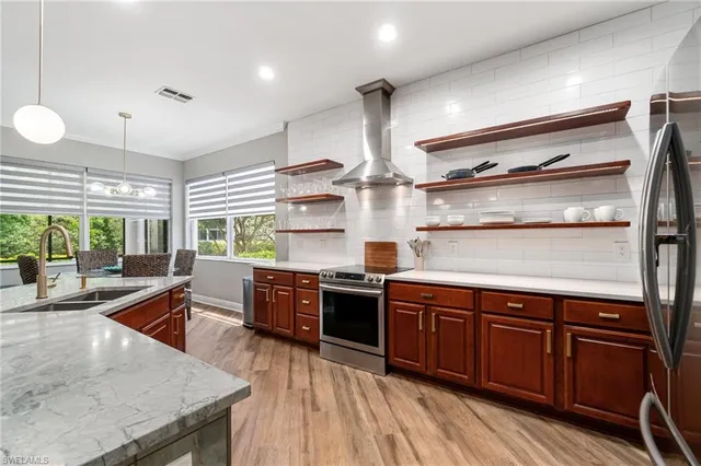 a large kitchen with stainless steel appliances granite countertop a large stove a sink dishwasher and cabinets with wooden floor