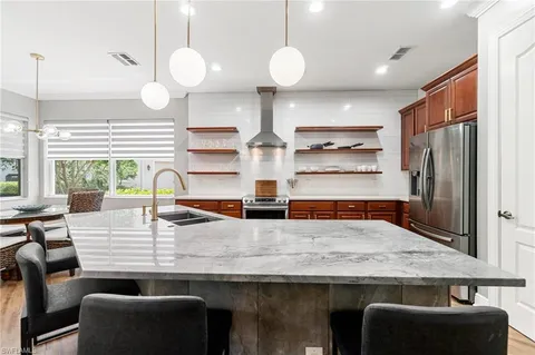 a kitchen with stainless steel appliances granite countertop a sink a stove and a refrigerator
