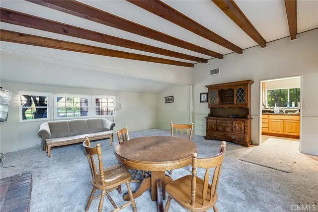 a view of a dining room with furniture and a kitchen