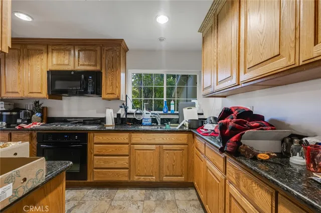 a kitchen with stainless steel appliances granite countertop a stove sink and cabinets