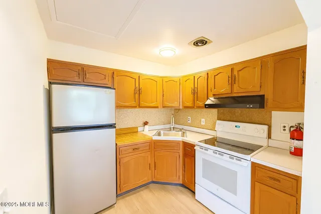 a kitchen with a refrigerator sink stove and cabinets