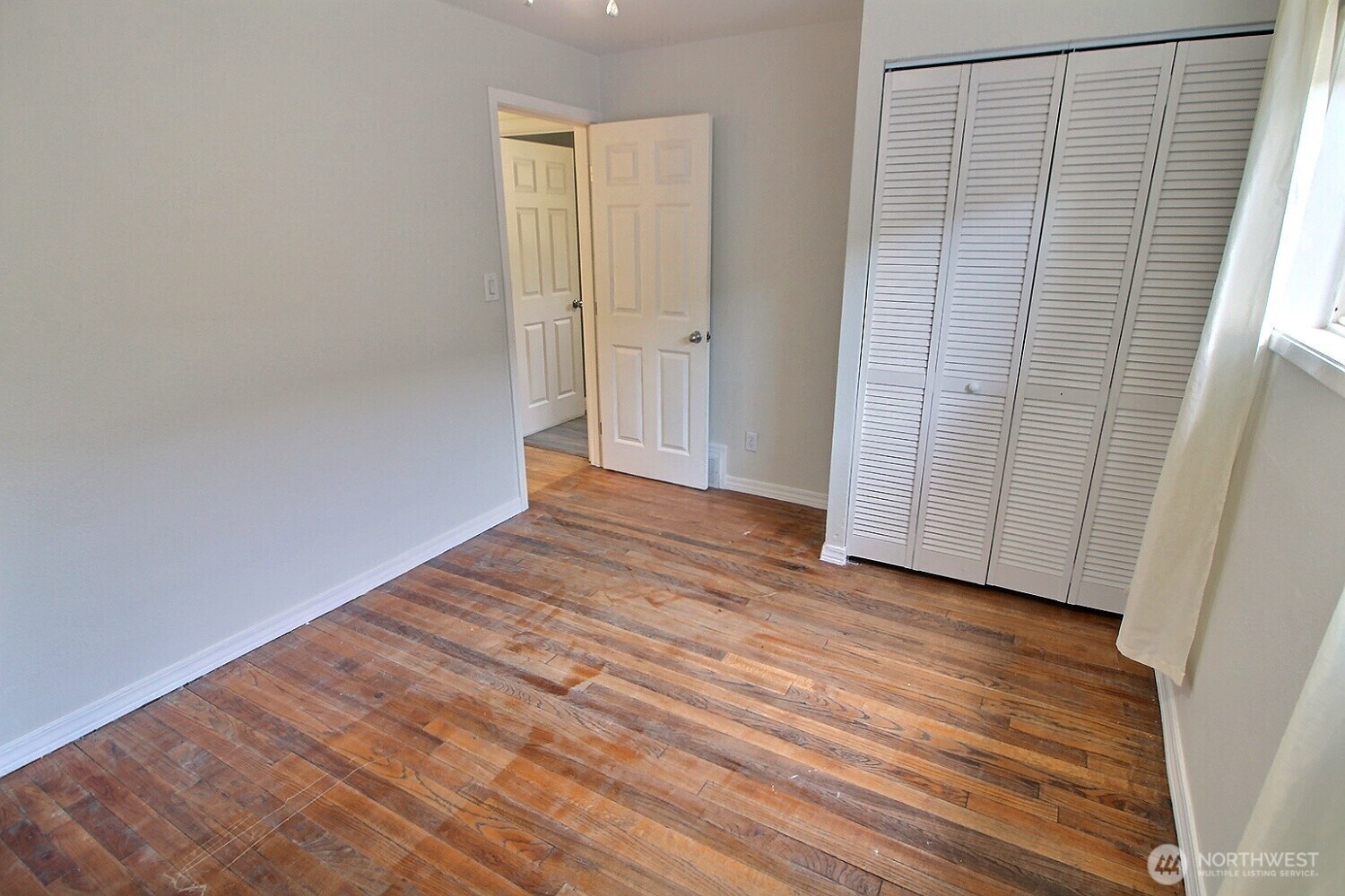 2309 Northeast 9th Place Renton, WA 98056 - Photo 12 of 38 a view of an empty room with wooden floor and a window