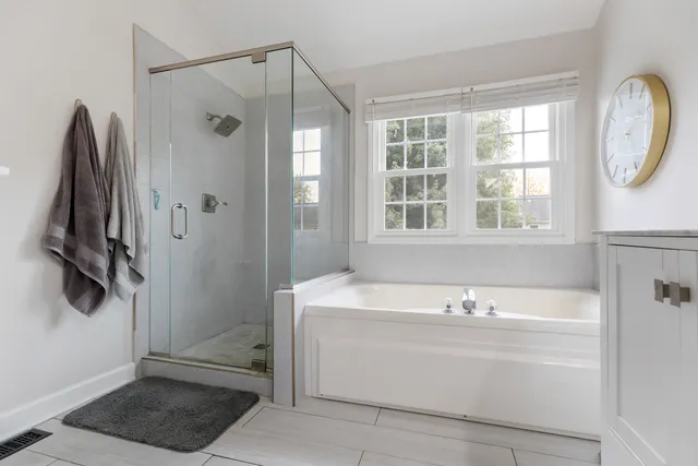 a bathroom with a tub a sink and a window