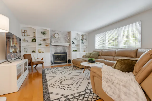 a living room with fireplace furniture and a large window