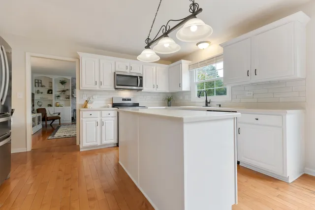 a kitchen with a sink cabinets stainless steel appliances and a window