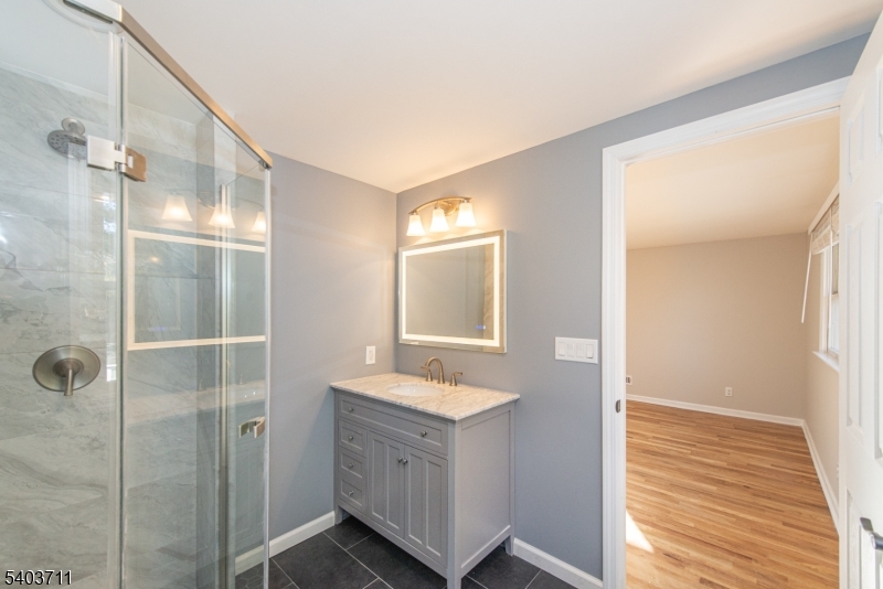 8 Abby Road Morristown, NJ 07960 - Photo 21 of 27 a bathroom with a sink a mirror and shower