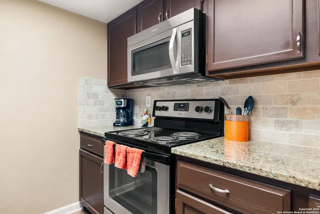 a kitchen with stainless steel appliances granite countertop a sink stove and cabinets