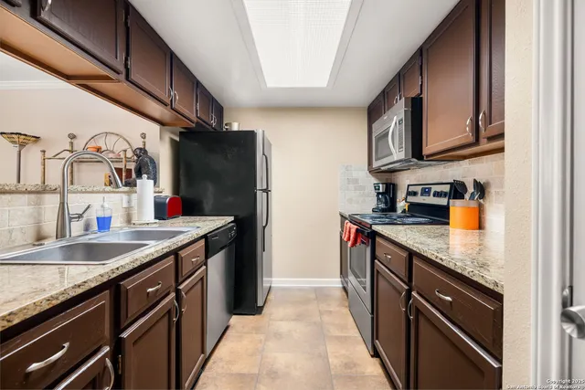 a kitchen with stainless steel appliances granite countertop a stove a sink and a microwave
