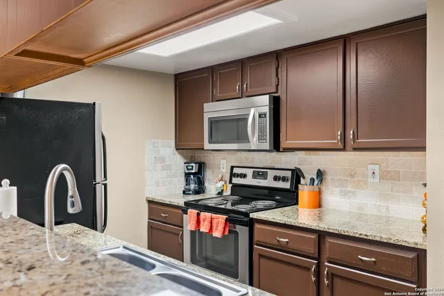 a kitchen with a sink a counter space and stainless steel appliances
