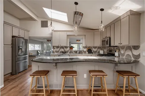 a kitchen with stainless steel appliances granite countertop a sink and refrigerator