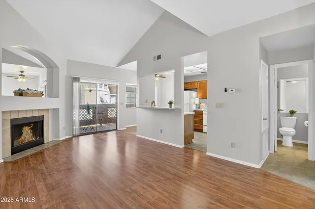 a view of a livingroom with wooden floor and a fireplace