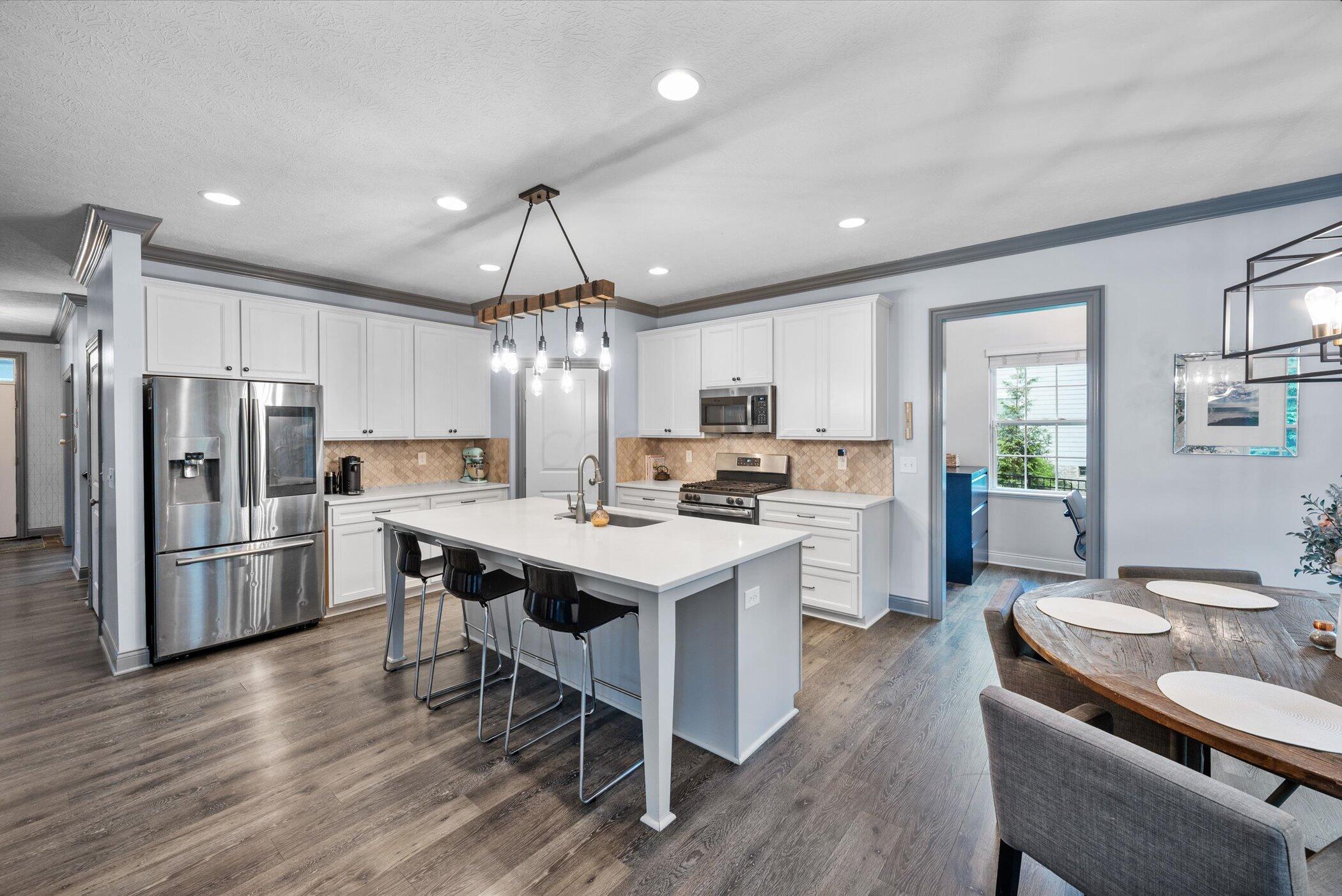 706 Bigham Ridge Boulevard Westerville, OH 43081 - Photo 14 of 62 Impressive Kitchen! Lots of light and space - note the open door to the pocket office which also leads to the mudroom and garage