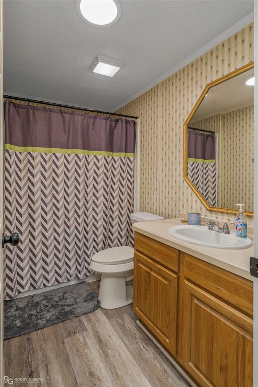 8273 Godfrey Road Shreveport, LA 71129 - Photo 21 of 27 Wood-finish flooring, single vanity with light-toned countertop, framed mirror, and recessed ceiling lighting