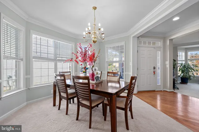 a kitchen with stainless steel appliances granite countertop a refrigerator a sink dishwasher a stove and white countertops with wooden floor