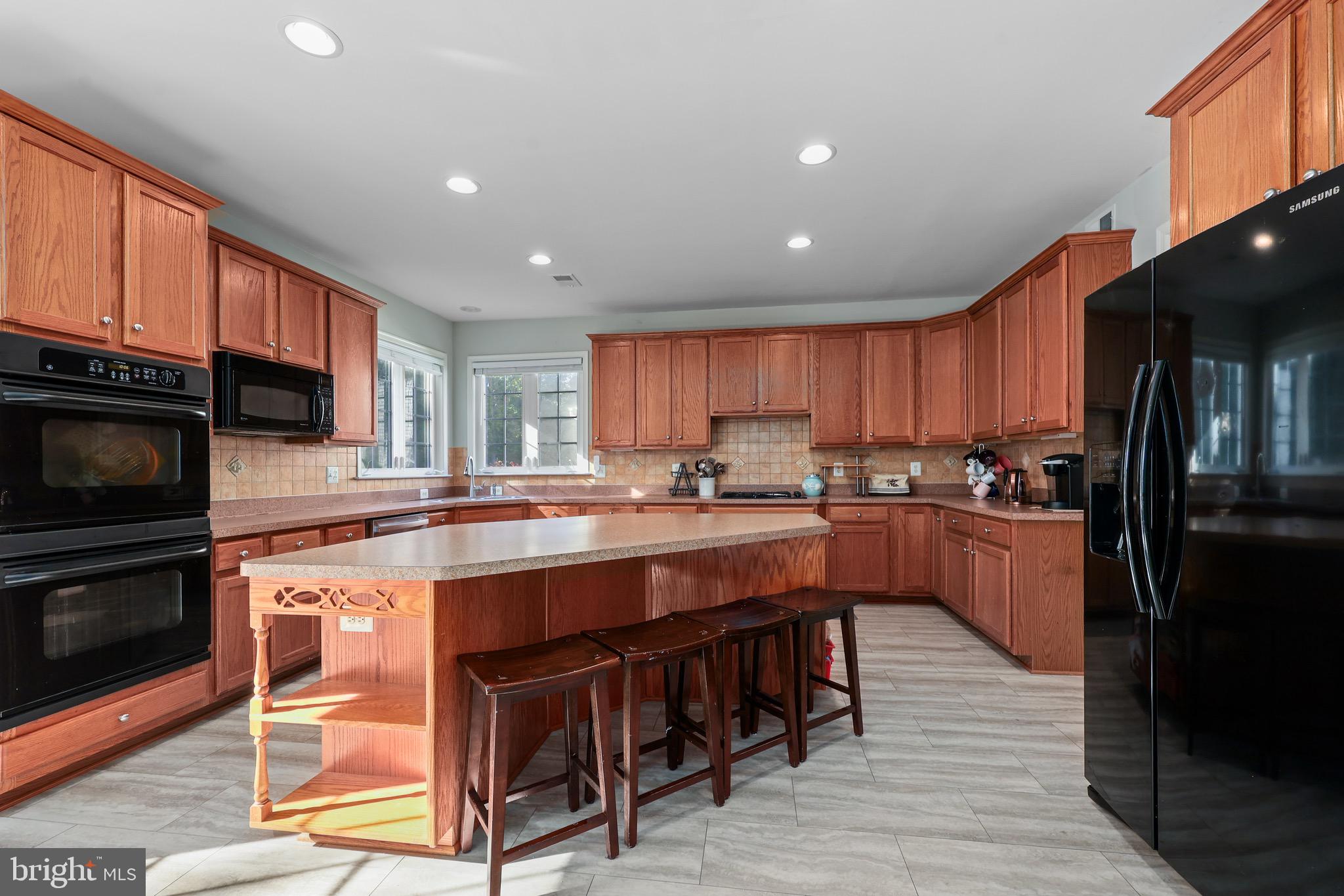 3671 Expedition Drive Triangle, VA 22172 - Photo 19 of 55 a large kitchen with stainless steel appliances granite countertop a stove and a refrigerator
