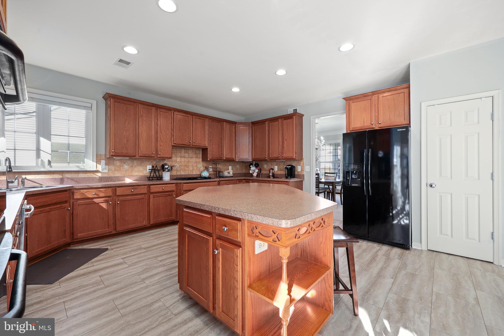 3671 Expedition Drive Triangle, VA 22172 - Photo 20 of 55 a kitchen with stainless steel appliances granite countertop a refrigerator a sink dishwasher a stove and white countertops with wooden floor