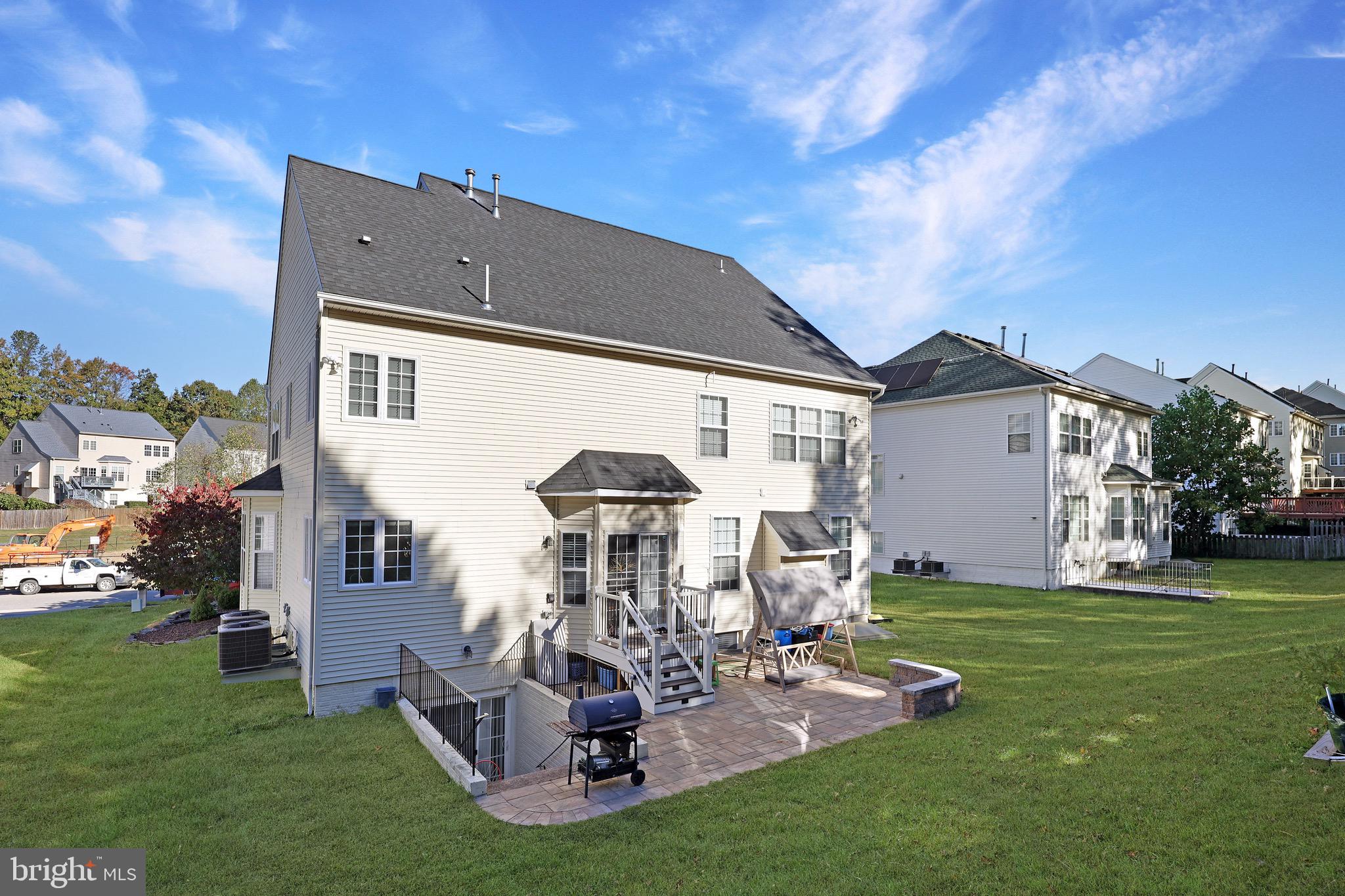 3671 Expedition Drive Triangle, VA 22172 - Photo 5 of 55 a front view of a house with a yard fire pit and outdoor seating