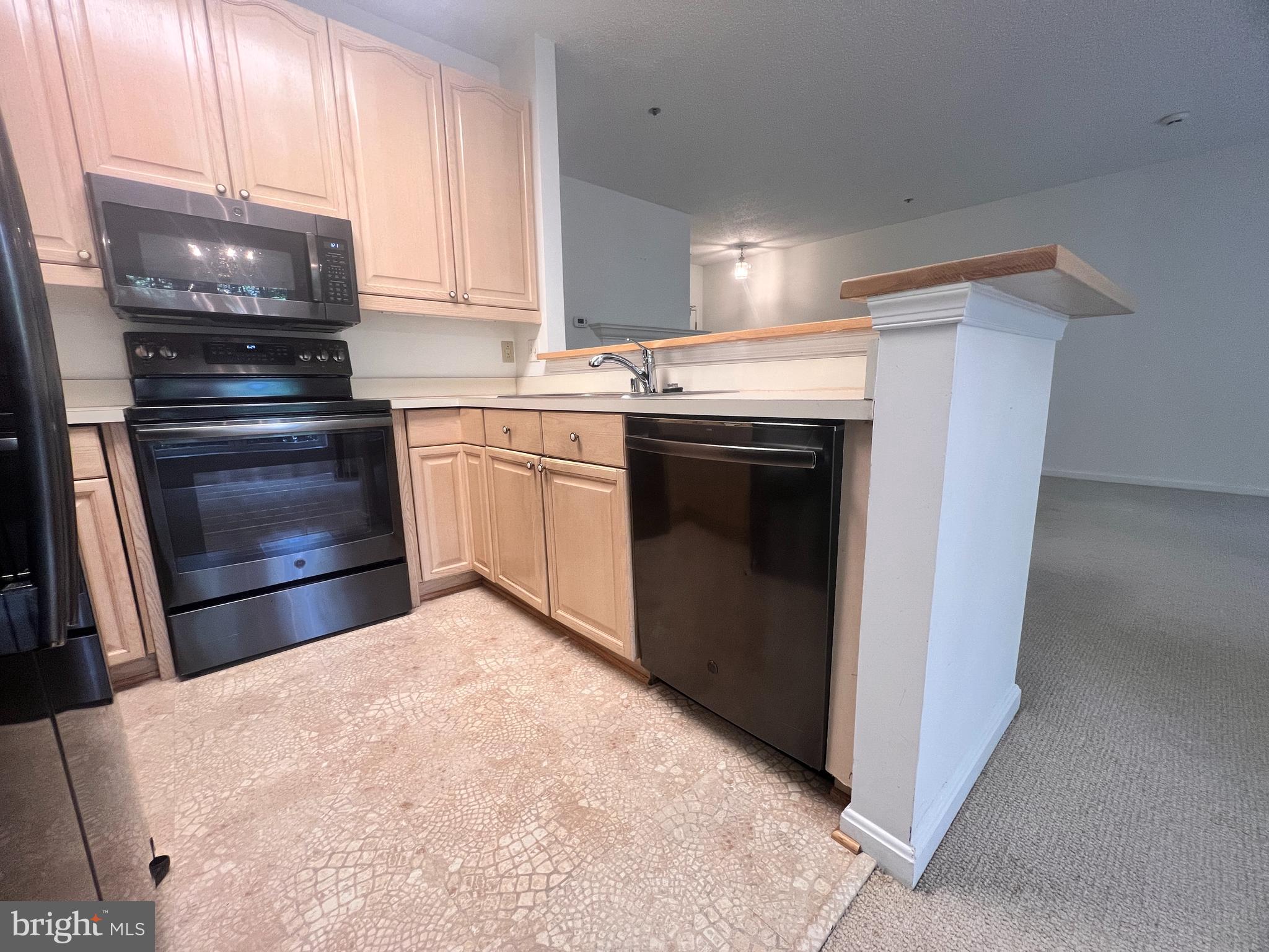 103 Square Rigger Way, Unit 103 Solomons, MD 20688 - Photo 12 of 21 a kitchen with stainless steel appliances a stove and a refrigerator