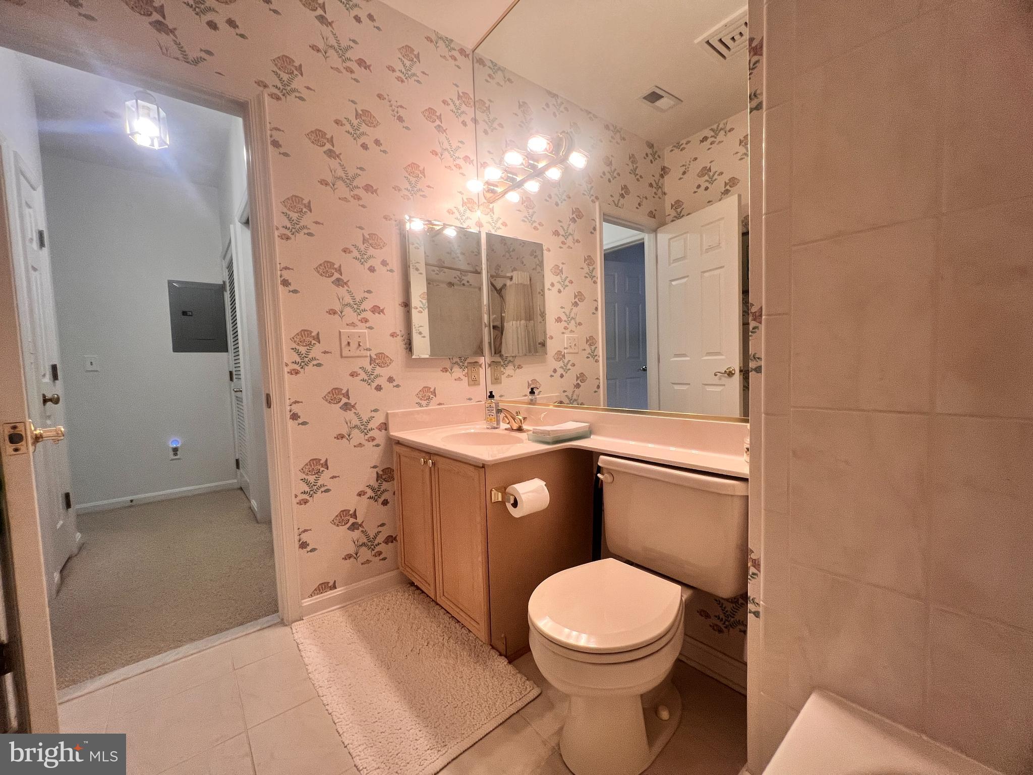 103 Square Rigger Way, Unit 103 Solomons, MD 20688 - Photo 16 of 21 a bathroom with a toilet a sink a mirror and shower