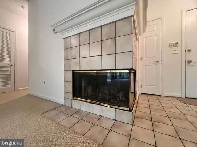 a view of an empty room with a fireplace and a window