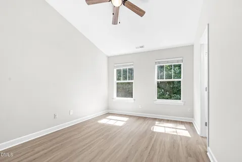 a view of a livingroom with a ceiling fan & windows
