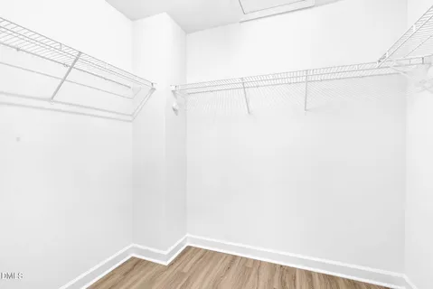 a view of a small space with wooden floor and a window